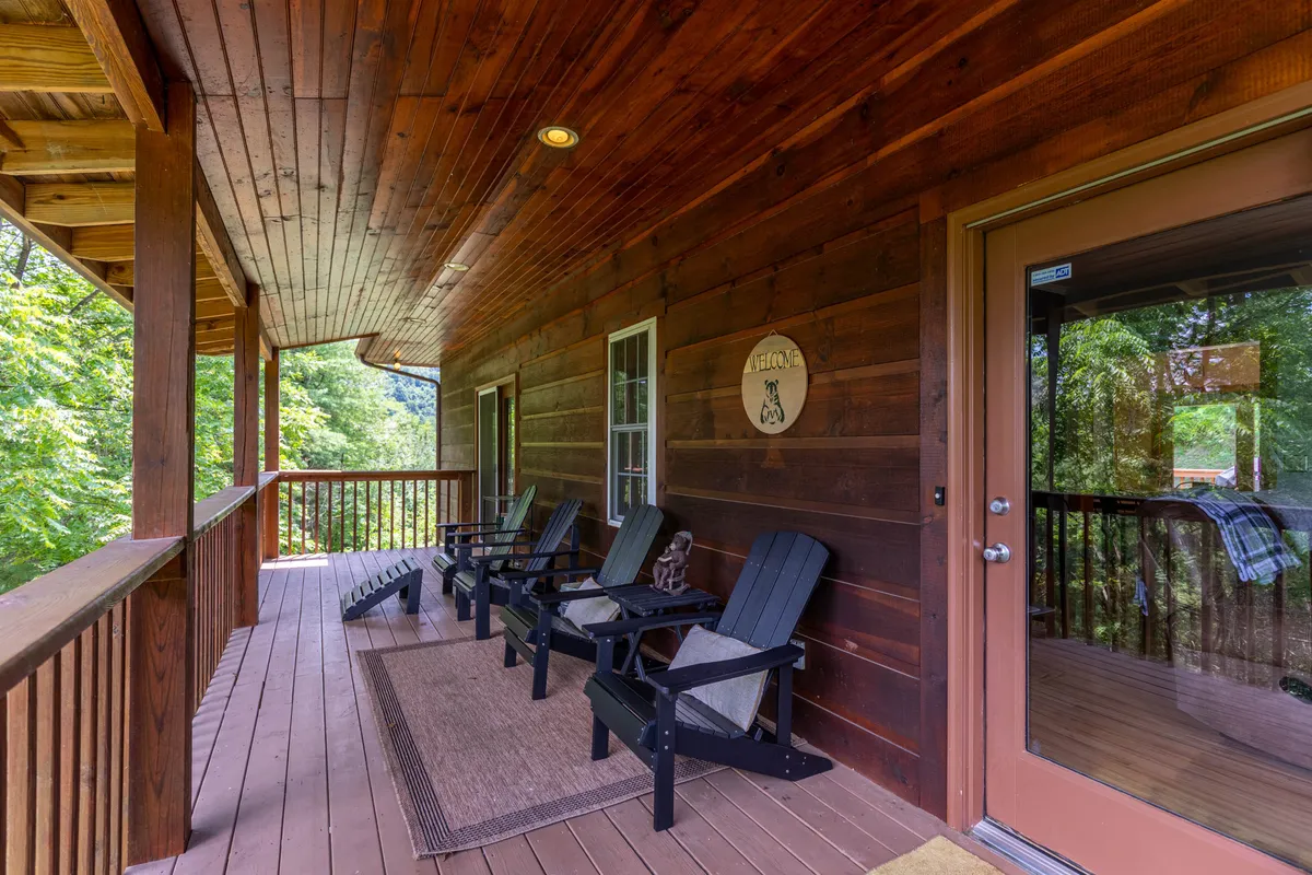 A wooden deck with inviting rocking chairs, a welcome sign, and morning light filtering through the trees. The scene exudes warmth and hospitality, and offers a comfortable spot to relax after outdoor adventures.